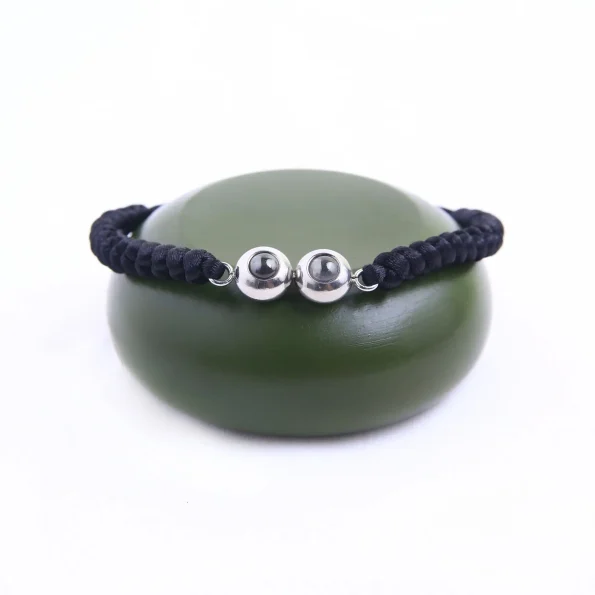 Black braided photo bracelet with double pendant, adding a personalized touch to your look