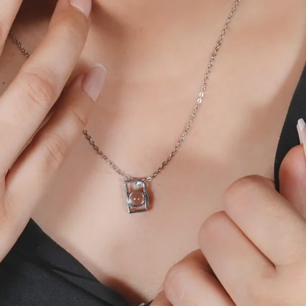 Girl wearing silver camera necklace, a stylish way to keep loved ones close