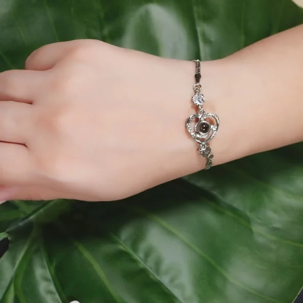 Model wearing silver heart charm bracelet, an elegant statement piece