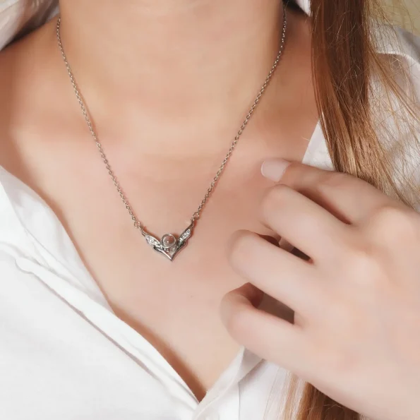 Model showcasing silver angel wings necklace, a delicate and meaningful accessory