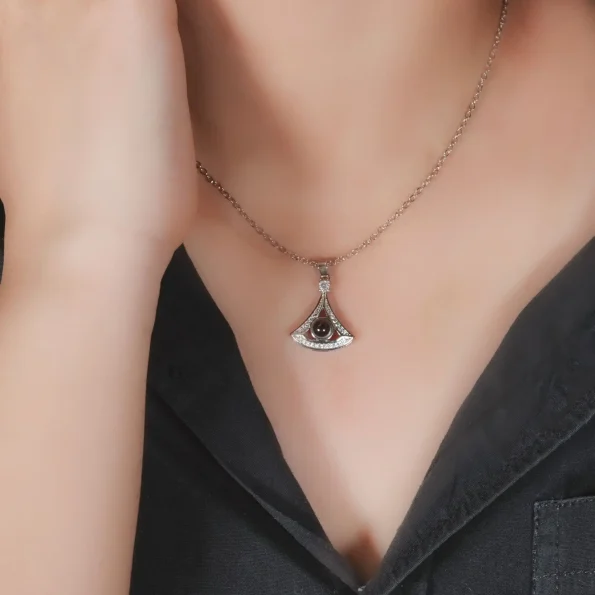 Model wearing silver fan-shaped necklace, a delicate photo keepsake
