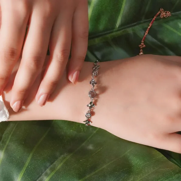 Model showcasing silver clover bracelet for a stylish look