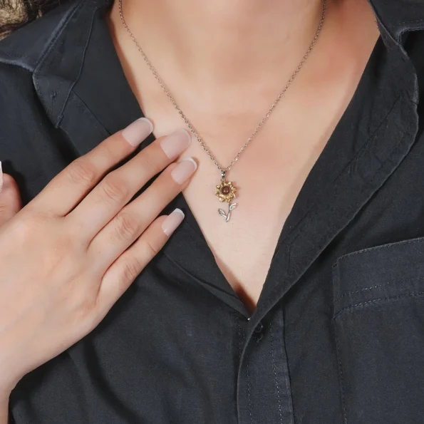 Model wearing gold and silver sunflower pendant, showcasing elegance with a hidden photo