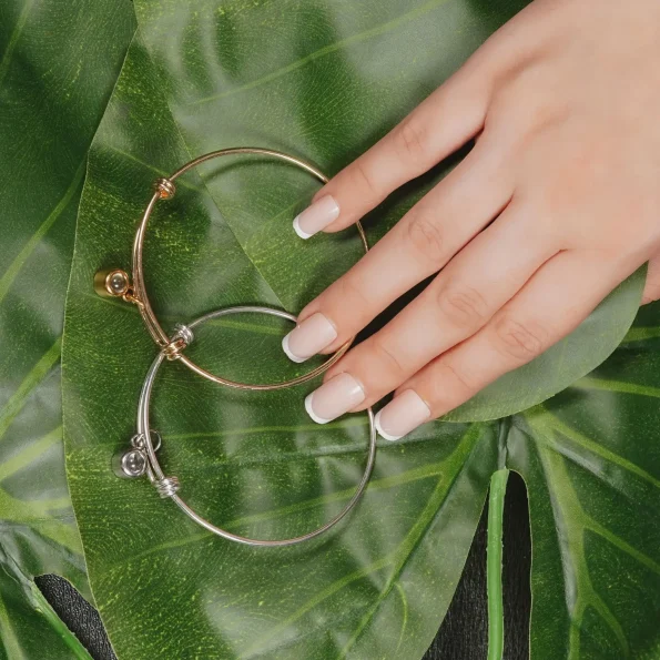 Photo projection bangles displayed on a green leaf and model’s hand, showcasing elegance and nature-inspired style