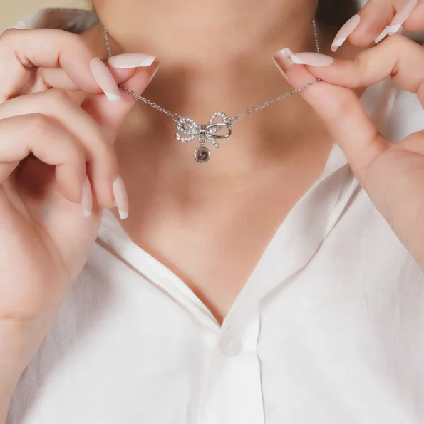 Woman holding silver knot locket, a stylish keepsake for special memories