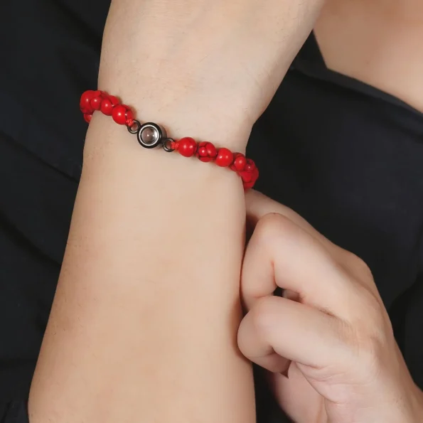 Woman wearing red frosted stone photo projection bracelet – meaningful gift