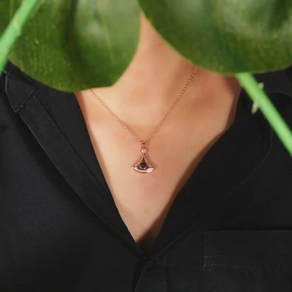 Woman wearing rose gold fan-shaped locket, blending elegance with personal memories