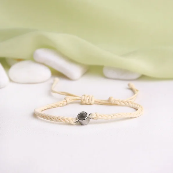 Subtle beige rope projection bracelet, a sentimental jewelry piece with a hidden personal touch.