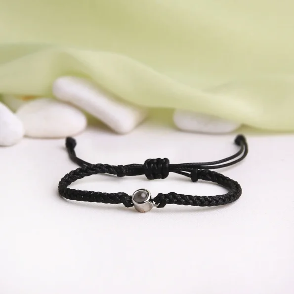 Sleek black rope projection bracelet with a timeless look, holding a secret memory inside.
