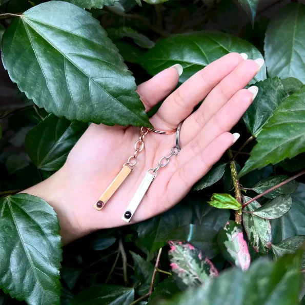 Girl holding a silver pillar photo keychain engraved with Haven of Jewels, a perfect way to remember cherished moments.