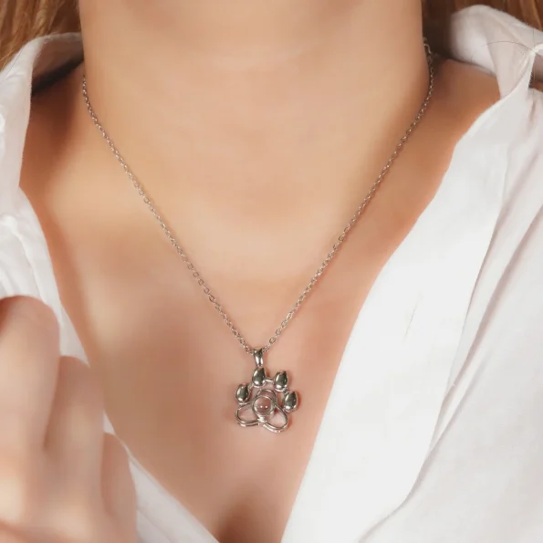 A girl wearing a silver pet paw necklace, a meaningful way to carry a beloved pet’s memory.