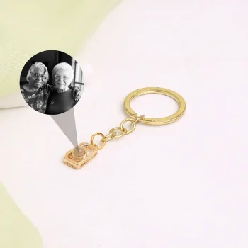Gold camera photo keychain with a hidden projection, a unique way to carry your most treasured moments.