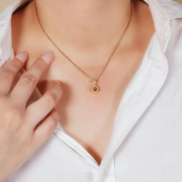 A woman wearing a gold petite halo necklace, exuding timeless sophistication and sentiment.