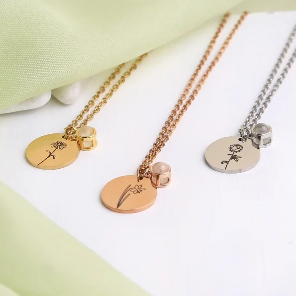 Group shot of birthflower photo necklaces in silver, gold, black, and rose gold, each carrying a hidden memory.