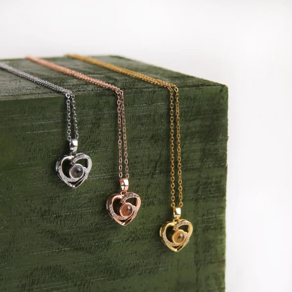 Group shot of silver, gold, and rose gold heart charm photo necklaces, timeless keepsakes for special moments.