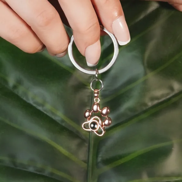 Model elegantly holding a gold pet photo keychain, a perfect keepsake for pet lovers.