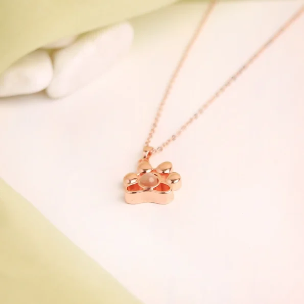 Rose gold pet paw necklace with a custom photo inside, a heartfelt keepsake for pet lovers.