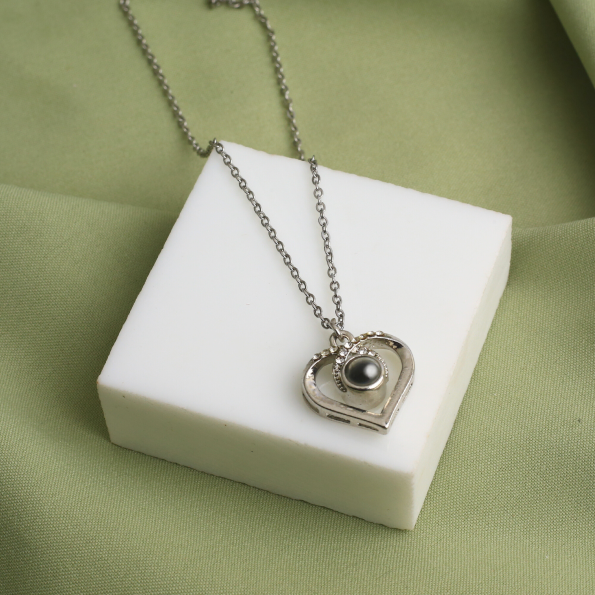 Elegant silver heart charm necklace with a hidden photo, a timeless keepsake of love and cherished memories.