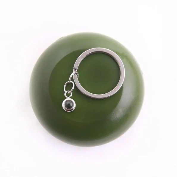 Elegant silver circle photo keychain with a hidden projection, perfect for carrying cherished memories close.