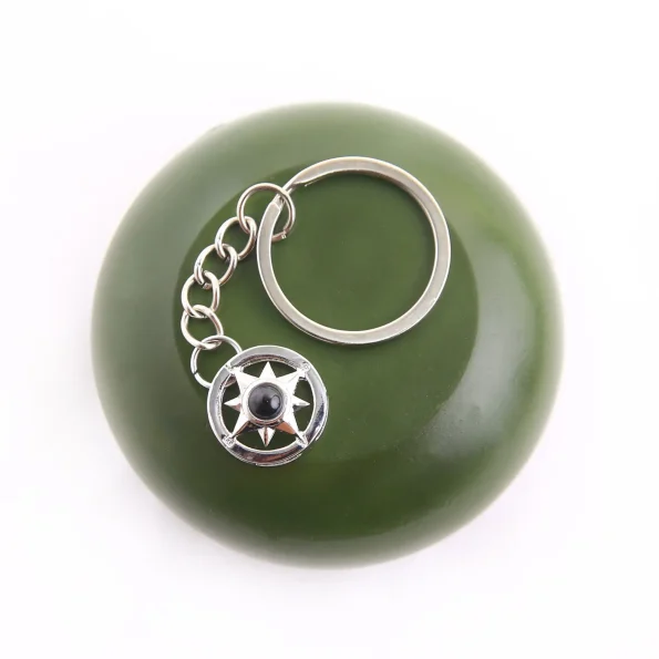 Elegant silver compass photo keychain with hidden projection, symbolizing guidance and cherished memories.