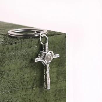 Silver heart and cross keychain with hidden projection, a sentimental accessory to keep cherished memories close.