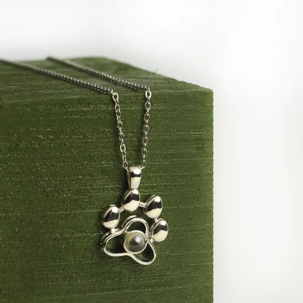 Elegant silver pet paw projection necklace with hidden photo, a timeless tribute to your furry friend.