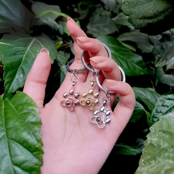 Woman holding pet photo keychains in silver, gold, and rose gold, highlighting stylish and sentimental designs.