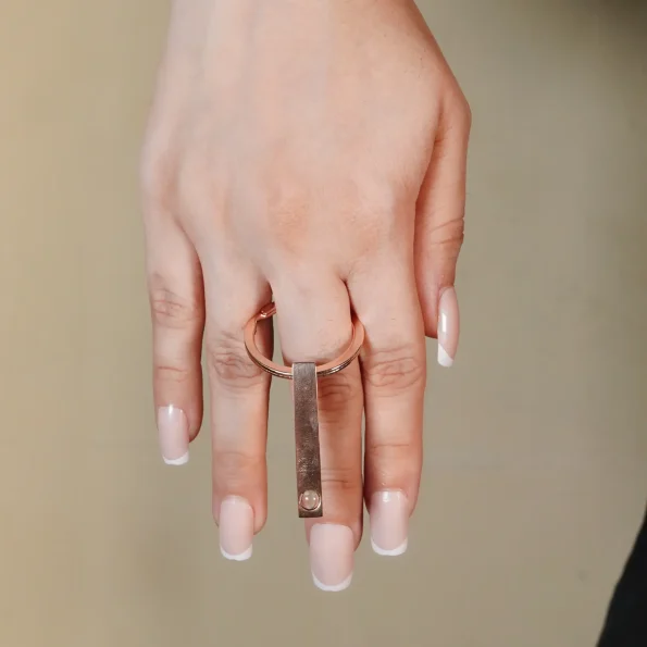 A woman holding an Osese gold bar photo keychain with a secret photo compartment, ideal for preserving special moments.