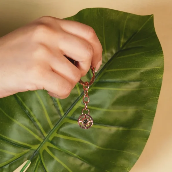 Woman holding a rose gold compass photo keychain, a heartfelt keepsake of treasured moments.