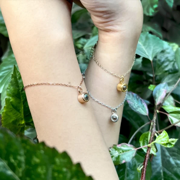 Woman wearing all charm bracelet colors, embracing a stylish and sentimental look.